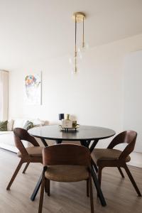 a dining room with a black table and chairs at Lets Go Raversijde in Ostend