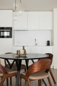 a dining room table with chairs and a kitchen at Lets Go Raversijde in Ostend