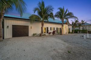 a garage with palm trees in front of a building at Honey I'm Holmes - New Home Near the Beach Turf in Anna Maria Island