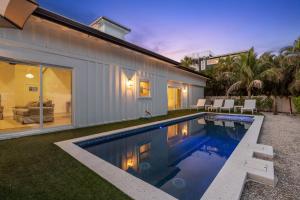 a swimming pool in the backyard of a house at Honey I'm Holmes - New Home Near the Beach Turf in Anna Maria Island +52 photos