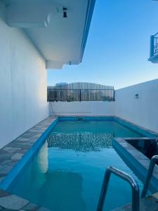 a swimming pool with blue lights in a room at Auralis Villa in Flic-en-Flac