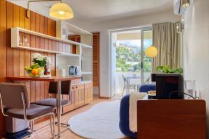 a kitchen and living room with a table and chairs at Aida's Place, a Home in Madeira in Ilhéu do Gorgulho