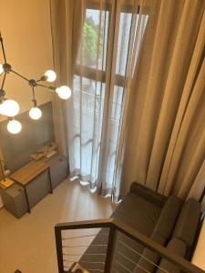 ein Wohnzimmer mit Couch und großem Fenster in der Unterkunft Studio BCN Higienópolis in São Paulo