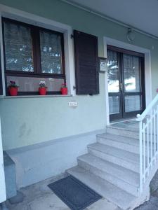 a house with stairs and windows with potted plants at Appartamento la Madonnina in Besenello
