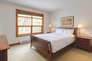 a bedroom with a large bed and a window at Classic Les Eaux Chalet w Sauna near the Mountains in Mont-Tremblant +41 photos