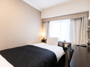 a hotel room with a bed and a window at APA Hotel Tennoji Ekimae in Osaka