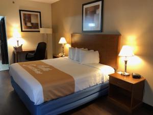 una camera d'albergo con un letto grande e due lampade di Days Inn By Wyndham Phenix City Near Fort Moore a Phenix City Altre 12 foto