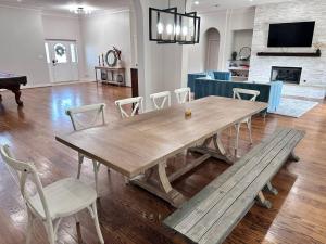 a dining room with a wooden table and a bench at Luxury Event and Stay in Celina, Texas in Gunter