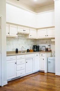 a white kitchen with white cabinets and a wooden floor at Luxury Event and Stay in Celina, Texas in Gunter +50 photos