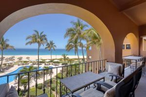 a balcony with a view of the beach and palm trees at Beachfront Condo at Casa del Mar in El Bedito