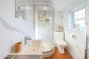 a white bathroom with a sink and a toilet at Lily Wood Cottage outside Hurlford in Hurlford +19 photos