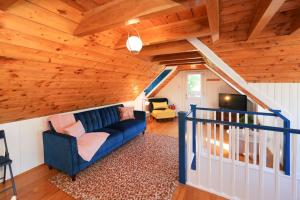 a living room with a blue couch and wooden ceilings at Lily Wood Cottage outside Hurlford in Hurlford