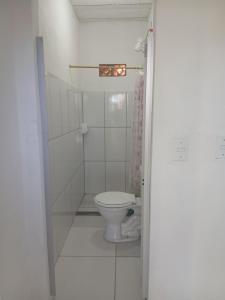 a white bathroom with a toilet in a room at Pousada Costeira Barra do Sul in Balneario Barra do Sul