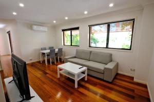 a living room with a couch and a tv at 2-Bedroom Apt with Terraces in Gold Coast