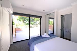 a bedroom with a bed and a large sliding glass door at 2-Bedroom Apt with Terraces in Gold Coast
