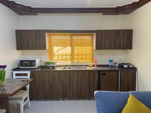 a kitchen with wooden cabinets and a microwave at Casa de petra in Wadi Musa