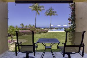 a table and chairs on a patio with a view of a yard at Beautiful Beachfront Condo With Spectacular Views in El Bedito