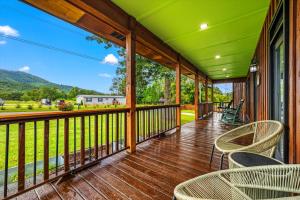 porche con sillas y vistas a las montañas en 2 Cabins in One- Hot Tub- Fenced Yard - Mtn Views, en Wear Valley
