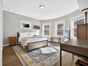 une chambre avec un lit, une table et des fenêtres dans l'établissement Luxury 3BR 2BA Boston Penthouse, à Boston
