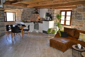 a kitchen and a living room with a couch and a table at Loft Cocoon in Mostuéjouls