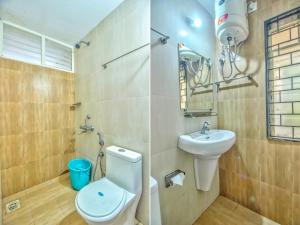 a bathroom with a toilet and a sink at Stunning 4bhk Pool View Apartment 2bhkX2 in Vagator