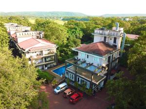 a house with a car parked in front of it at Stunning 4bhk Pool View Apartment 2bhkX2 in Vagator