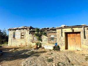 an old stone house with a wooden door at Refuge AIT M'HAMED in Aït Mehammed