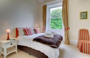 a bedroom with a large bed and a window at Taylors Beadnell House Apts in Beadnell