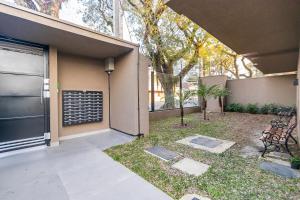 a patio with a bench next to a building at Studio Completo ao Lado da PUC - CAP109 in Curitiba