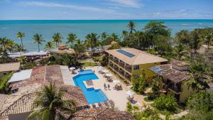 an aerial view of a resort with a pool and the ocean at Arraial Bangalô Praia Hotel in Arraial d'Ajuda