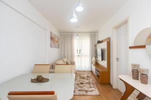 een witte woonkamer met een tafel en een bank bij Apartamento de 1 Quarto com Sofa-Cama - CEN1104 in Curitiba