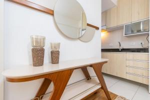 een keuken met een tafel met twee vazen erop bij Apartamento de 1 Quarto com Sofa-Cama - CEN1104 in Curitiba