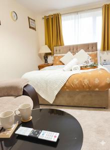 a bedroom with a bed and a coffee table at The RS Inn Cozy Homestay Premium Private Rooms With Parking Near Birmingham Airport, Lake Park For Solo, Couples & Family in Kingshurst +22 photos