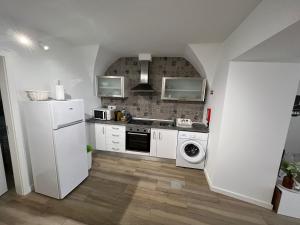 a kitchen with a white refrigerator and a dishwasher at Casa dos Albardeiros in Moura