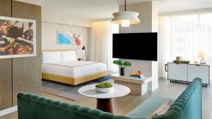 a bedroom with a bed and a living room with a couch at The Hollywood Grande, Autograph Collection in Los Angeles