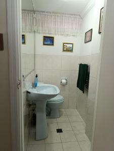 um banheiro branco com vaso sanitário e pia em Skyline 11, comfort in the heart of the city 