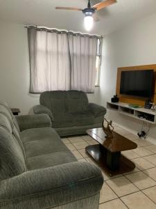 un soggiorno con due divani e una TV a schermo piatto di Apartamento temporada Cabo Frio a Cabo Frio