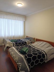 duas camas de solteiro em um quarto com janela em Skyline 11, comfort in the heart of the city 