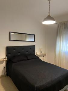 a bedroom with a black bed and a mirror at Olivos Stay in Olivos