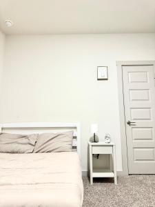 a white bedroom with a bed and a door at Peaceful Room in Austin in Austin