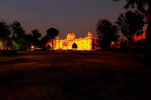 a building lit up at night with red lights at The Lallgarh Palace - A Heritage Hotel in Bikaner