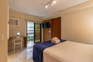 a bedroom with a bed and a desk and a window at 6 minutos da Praia do Leblon - GSM103 in Rio de Janeiro