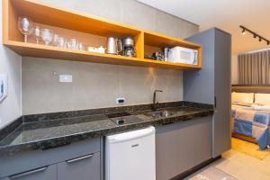 a kitchen with a sink and a bed in a room at Estúdio Completo para 4 Pessoas no Eixo - EIX0201 in Curitiba
