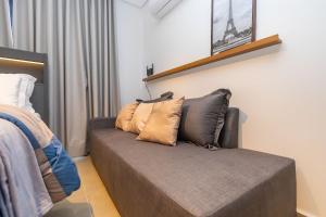 a couch with pillows on it in a bedroom at Estúdio Completo para 4 Pessoas no Eixo - EIX0201 in Curitiba