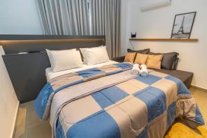 a bedroom with a large bed with a blue and white comforter at Estúdio Completo para 4 Pessoas no Eixo - EIX0201 in Curitiba +51 photos