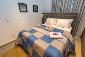 a bedroom with a bed with two towels on it at Estúdio Completo para 4 Pessoas no Eixo - EIX0201 in Curitiba