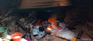 a fireplace with pots and pans and a fire at Refuge AIT M'HAMED in Aït Mehammed