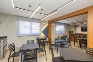 a restaurant with tables and chairs and a bar at Estúdio Completo para 4 Pessoas no Eixo - EIX0201 in Curitiba