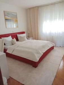 Un dormitorio con una cama grande con cabecero rojo. en Vila Maria II, en Vinkovci