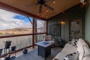 a screened in porch with a couch and a table at The Raven in Beech Mountain